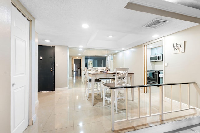 corridor featuring a textured ceiling and light tile patterned floors