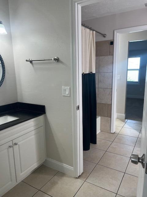 bathroom with a shower with shower curtain, vanity, and tile patterned flooring