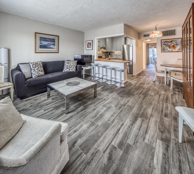 living room with wood-type flooring and a textured ceiling