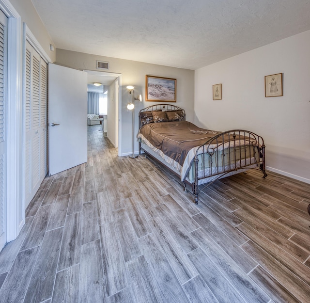 bedroom featuring hardwood / wood-style floors and a textured ceiling