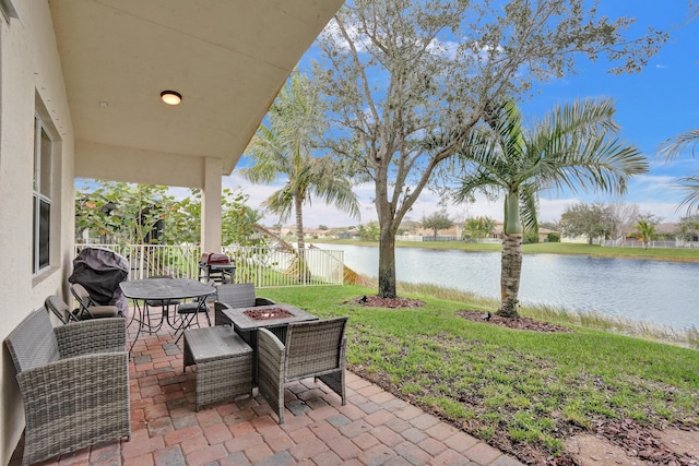 view of patio / terrace with a water view, grilling area, and a fire pit