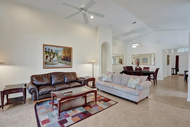 tiled living room with ceiling fan and high vaulted ceiling