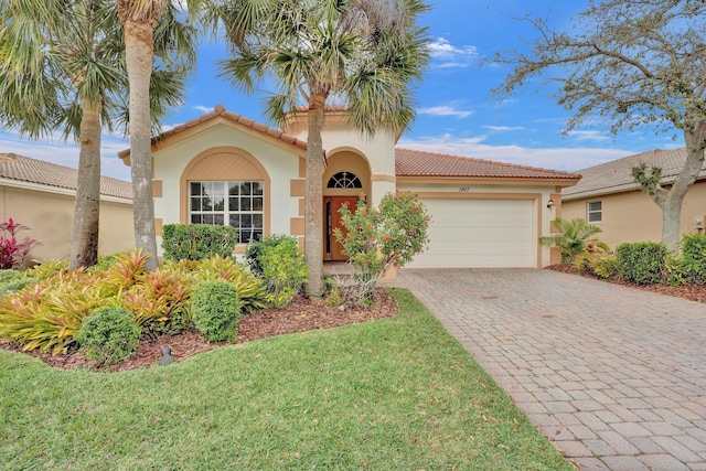 mediterranean / spanish-style house with a garage and a front lawn