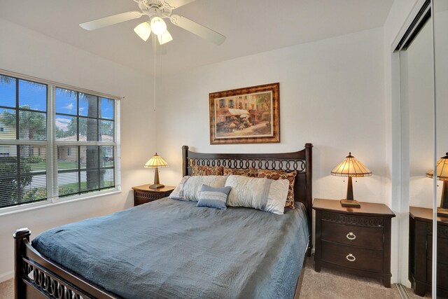 bedroom featuring light carpet, a closet, and ceiling fan