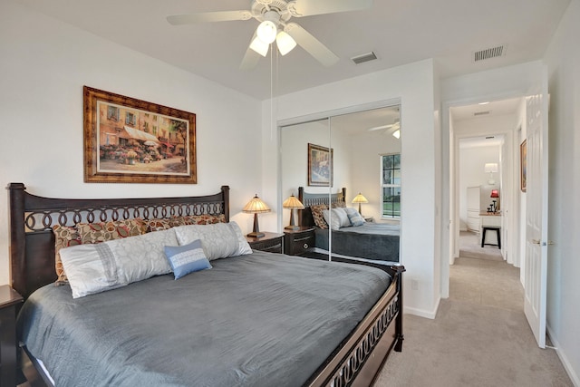 bedroom with ceiling fan, a closet, and light carpet