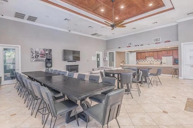 dining room with wood ceiling, crown molding, a towering ceiling, light tile patterned flooring, and a raised ceiling