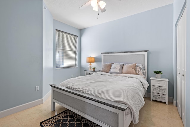 bedroom with a closet, ceiling fan, a textured ceiling, and baseboards