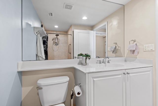 bathroom featuring toilet, a stall shower, vanity, and visible vents