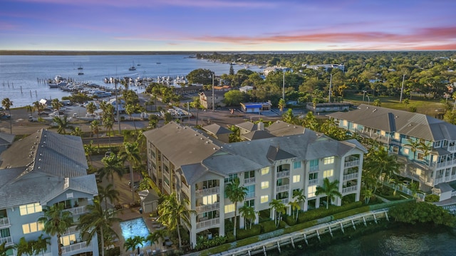 aerial view at dusk featuring a water view