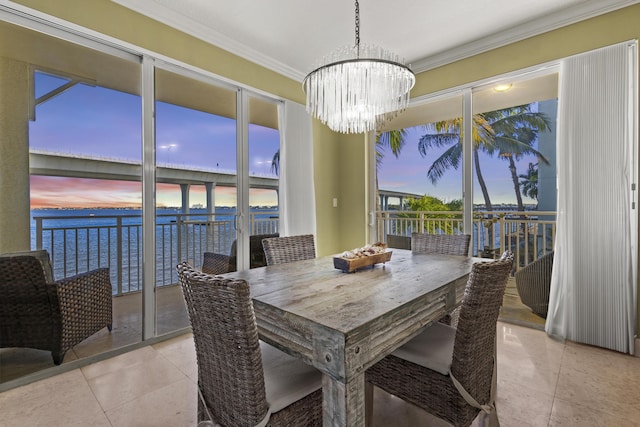 dining room featuring a chandelier, ornamental molding, a water view, and light tile patterned floors