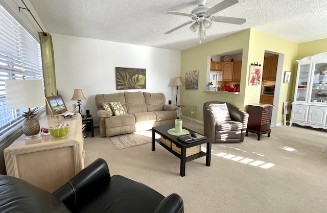 carpeted living room featuring ceiling fan and a textured ceiling