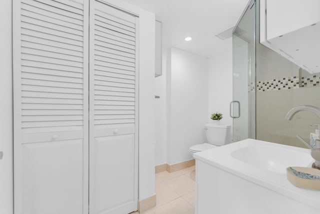 bathroom featuring tile patterned floors, toilet, a shower with shower door, and sink