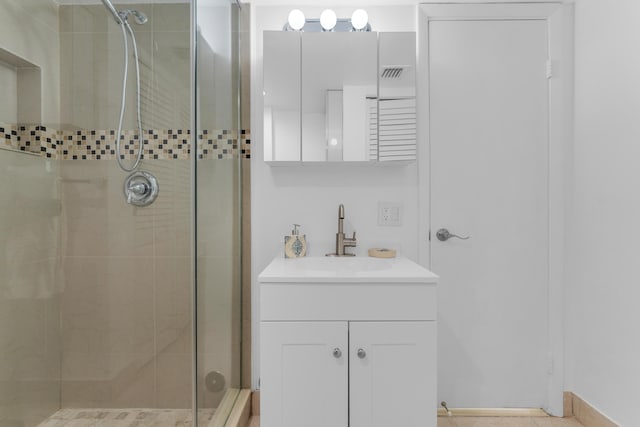 bathroom featuring a shower with door and vanity