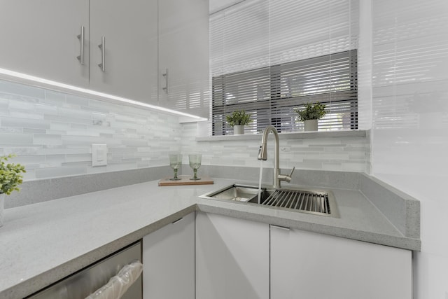 kitchen with sink, decorative backsplash, dishwasher, and white cabinets