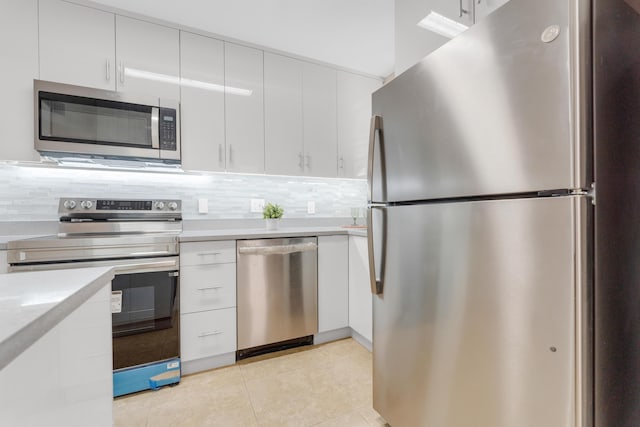 kitchen featuring white cabinetry, light tile patterned floors, decorative backsplash, and appliances with stainless steel finishes