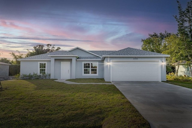 single story home with a garage and a yard