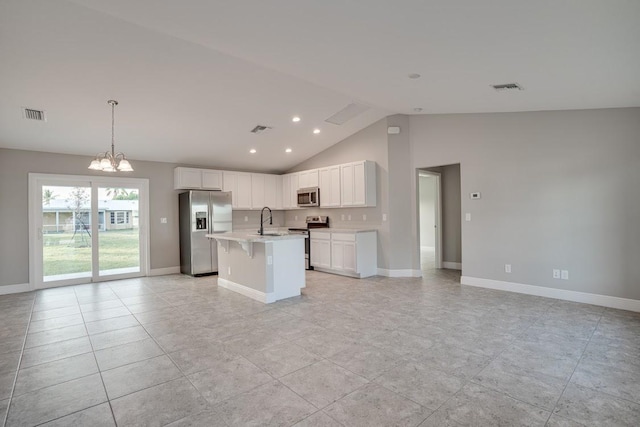 kitchen featuring sink, appliances with stainless steel finishes, white cabinetry, an island with sink, and a chandelier