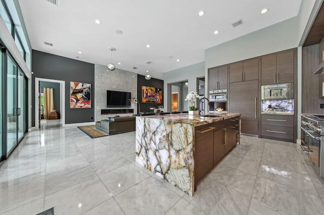 kitchen featuring a large island, modern cabinets, a sink, and high quality appliances