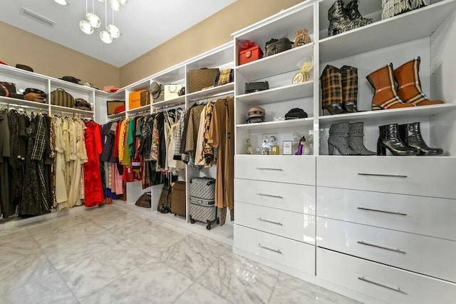 spacious closet with a chandelier and visible vents