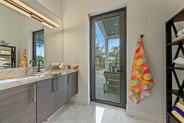 bathroom featuring marble finish floor, vanity, and baseboards