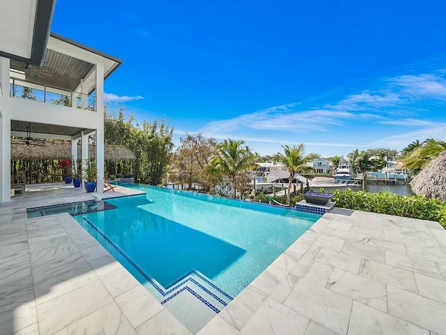 view of pool with an infinity pool and a patio area