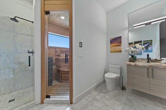 bathroom featuring a stall shower, vanity, toilet, and baseboards