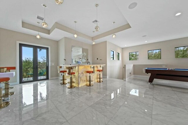 game room with a raised ceiling, visible vents, marble finish floor, and french doors