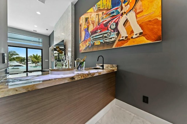 bar with recessed lighting, visible vents, a sink, and baseboards