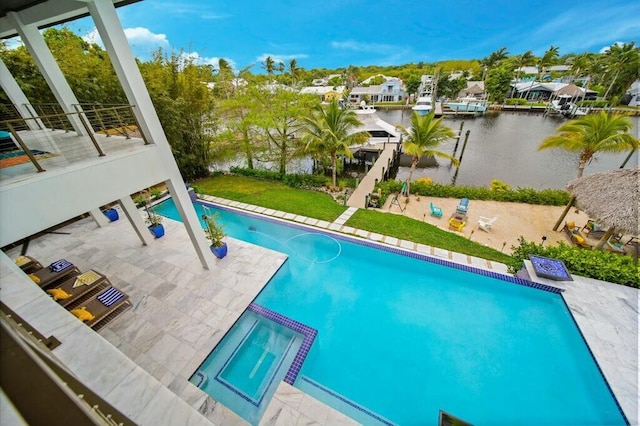 view of pool featuring a yard, a patio, a water view, and a pool with connected hot tub