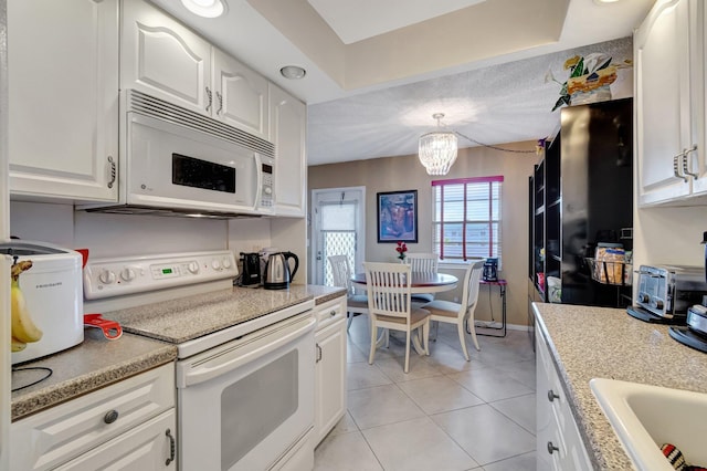 kitchen featuring white appliances, hanging light fixtures, white cabinetry, and light tile patterned floors