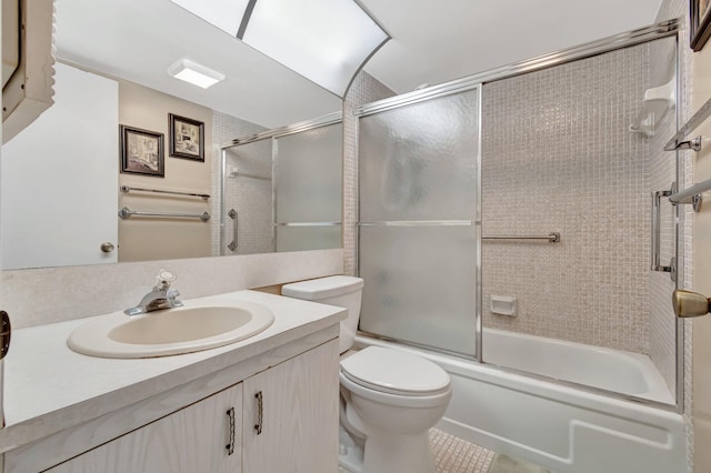 full bathroom with shower / bath combination with glass door, vanity, toilet, and tile patterned floors