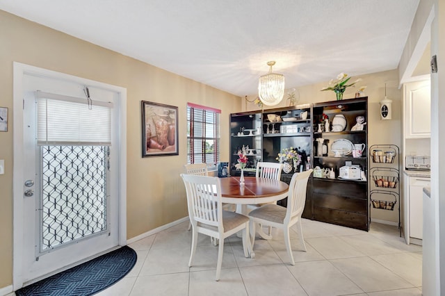 dining area with light tile patterned flooring and an inviting chandelier