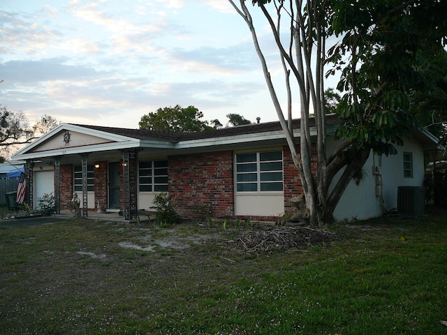 single story home with central AC, a garage, and a front yard