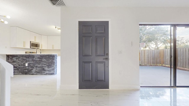 interior space featuring marble finish floor, visible vents, and baseboards