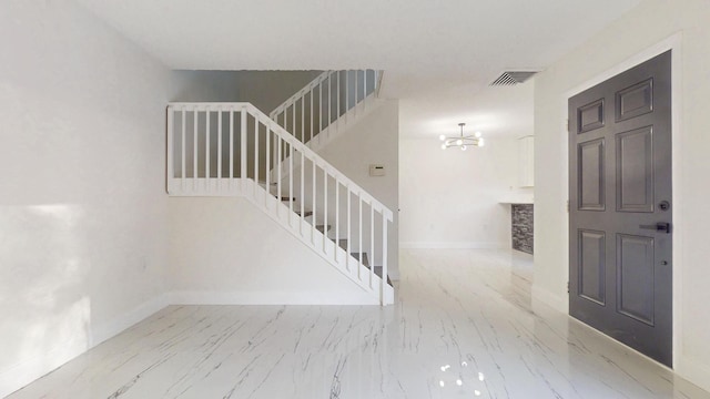 foyer entrance with marble finish floor, stairway, visible vents, and baseboards