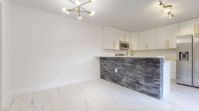 kitchen featuring stainless steel appliances, light countertops, and white cabinetry