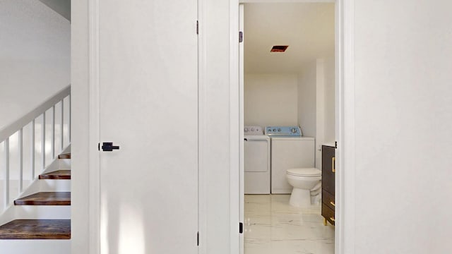 bathroom featuring toilet, marble finish floor, washing machine and dryer, and vanity