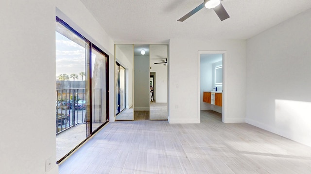 unfurnished bedroom featuring baseboards, connected bathroom, ceiling fan, access to exterior, and a textured ceiling