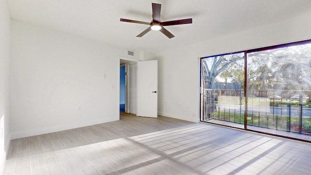 empty room featuring light wood-type flooring, visible vents, ceiling fan, and baseboards