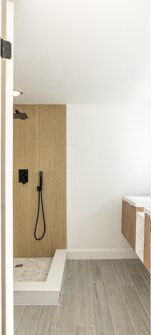 full bathroom featuring wood tiled floor, a shower stall, and baseboards