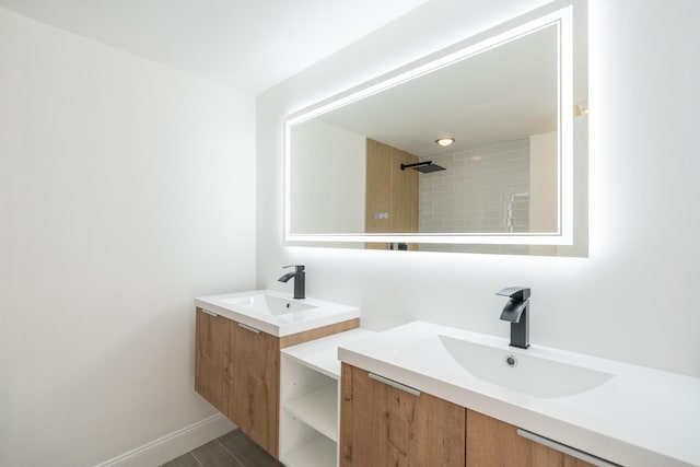 bathroom featuring two vanities, a sink, and baseboards