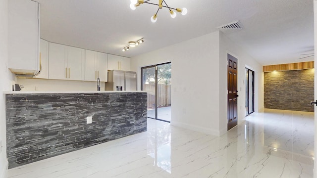 kitchen featuring marble finish floor, stainless steel refrigerator with ice dispenser, light countertops, visible vents, and white cabinetry