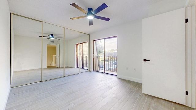 unfurnished bedroom featuring light wood-type flooring, access to outside, baseboards, and a ceiling fan