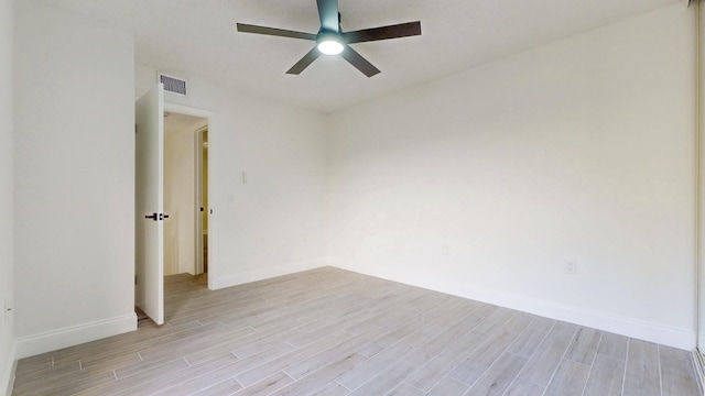 unfurnished room featuring baseboards, visible vents, ceiling fan, and light wood finished floors