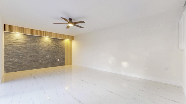 spare room with a ceiling fan and marble finish floor