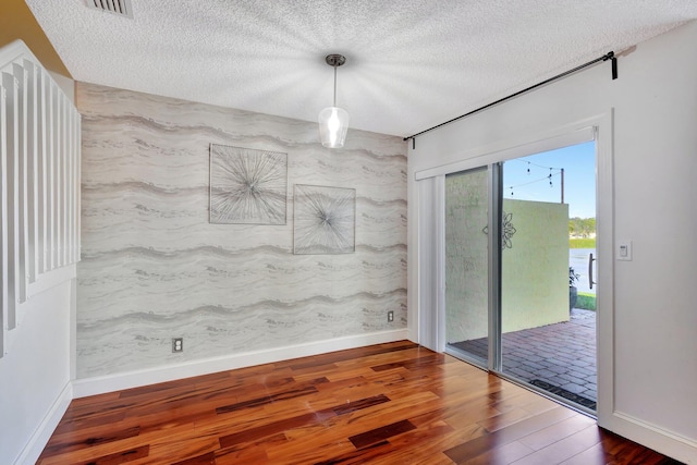 empty room featuring a textured ceiling and dark hardwood / wood-style floors