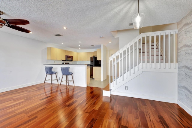 interior space featuring hardwood / wood-style floors, ceiling fan, and a textured ceiling