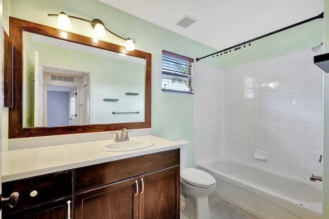 full bathroom with tiled shower / bath combo, vanity, tile patterned flooring, and toilet