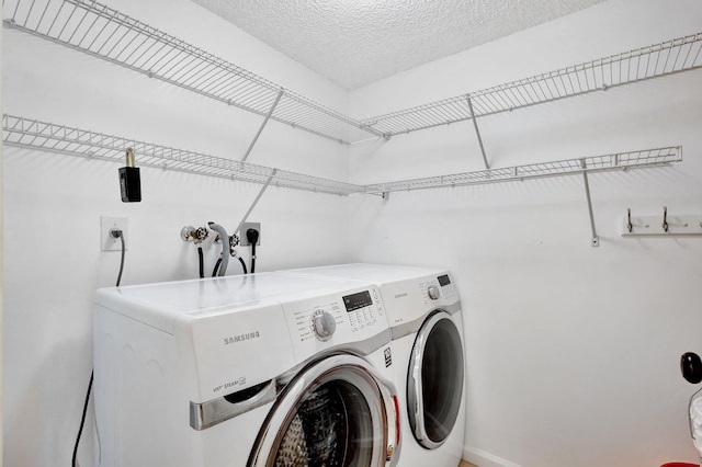 laundry area featuring a textured ceiling and separate washer and dryer