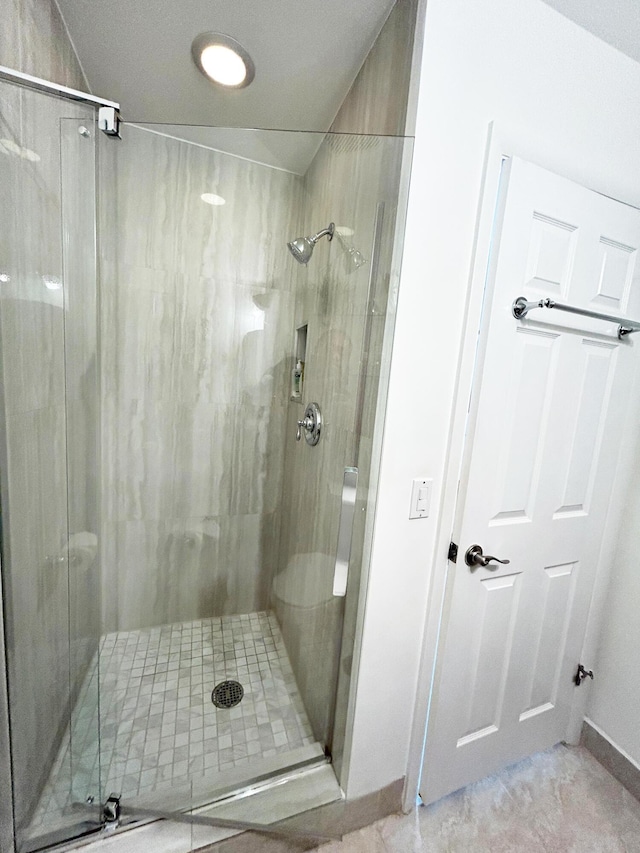 bathroom with a shower with door